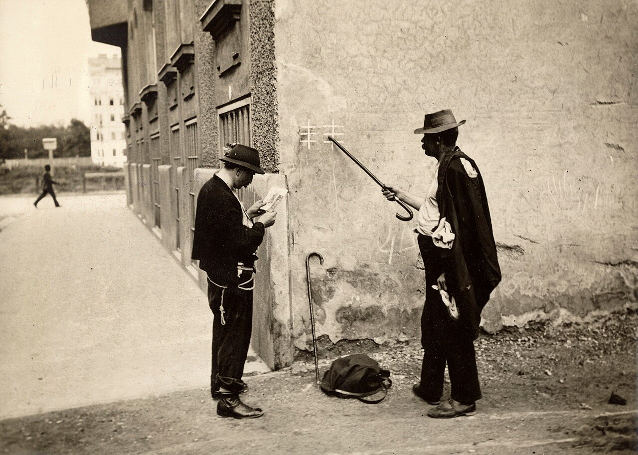 Men examining chalk signs on a wall