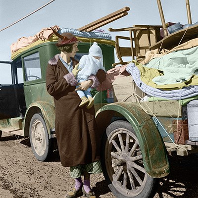 Migrant mother and child by a loaded car (colorized)